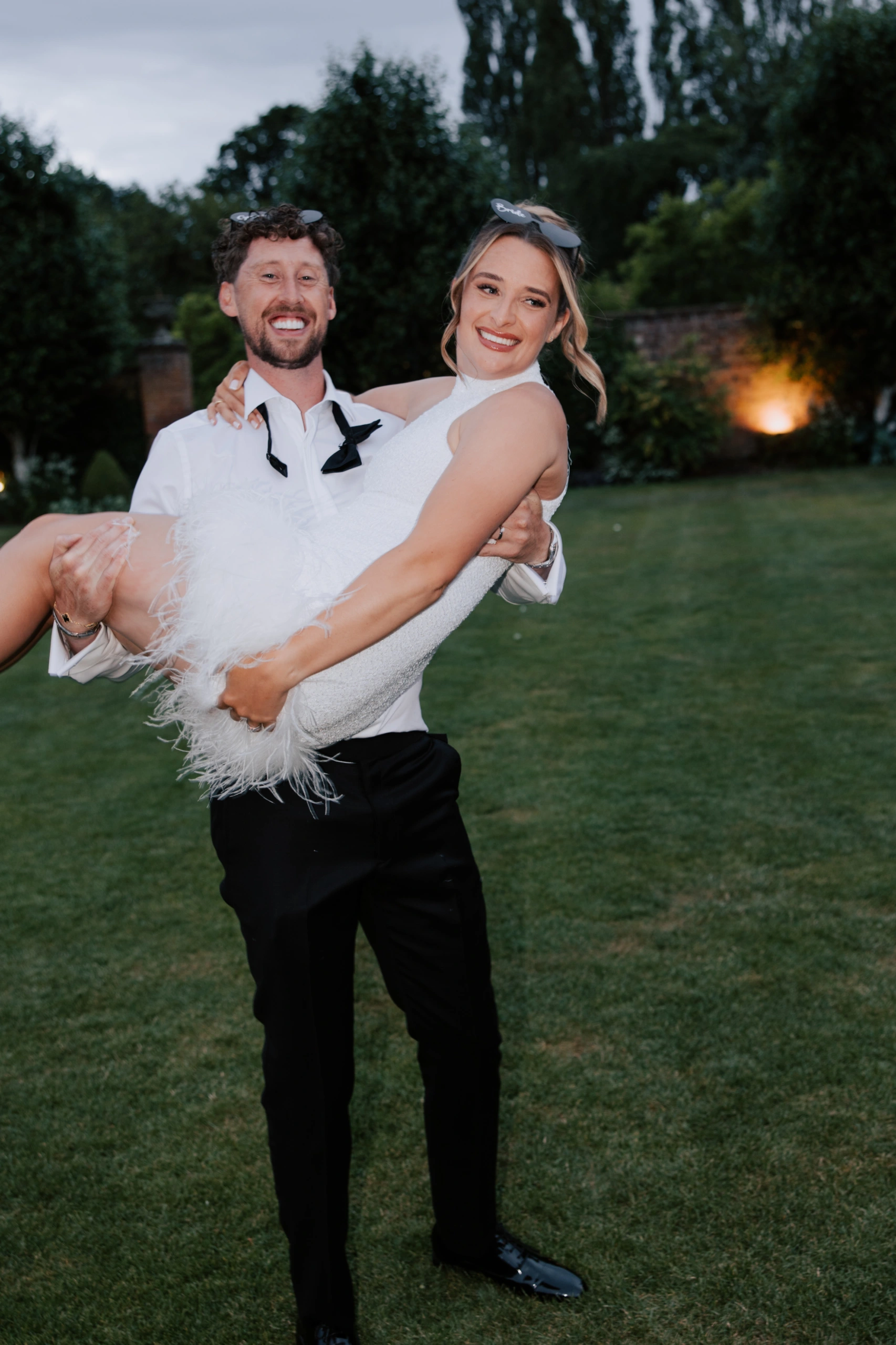 Joe carrying Ella in the gardens during the evening